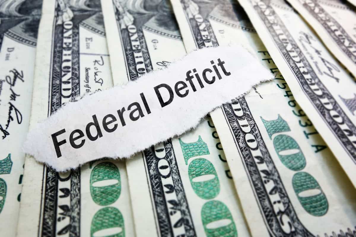 Federal Deficit newspaper scrap on hundred dollar bills