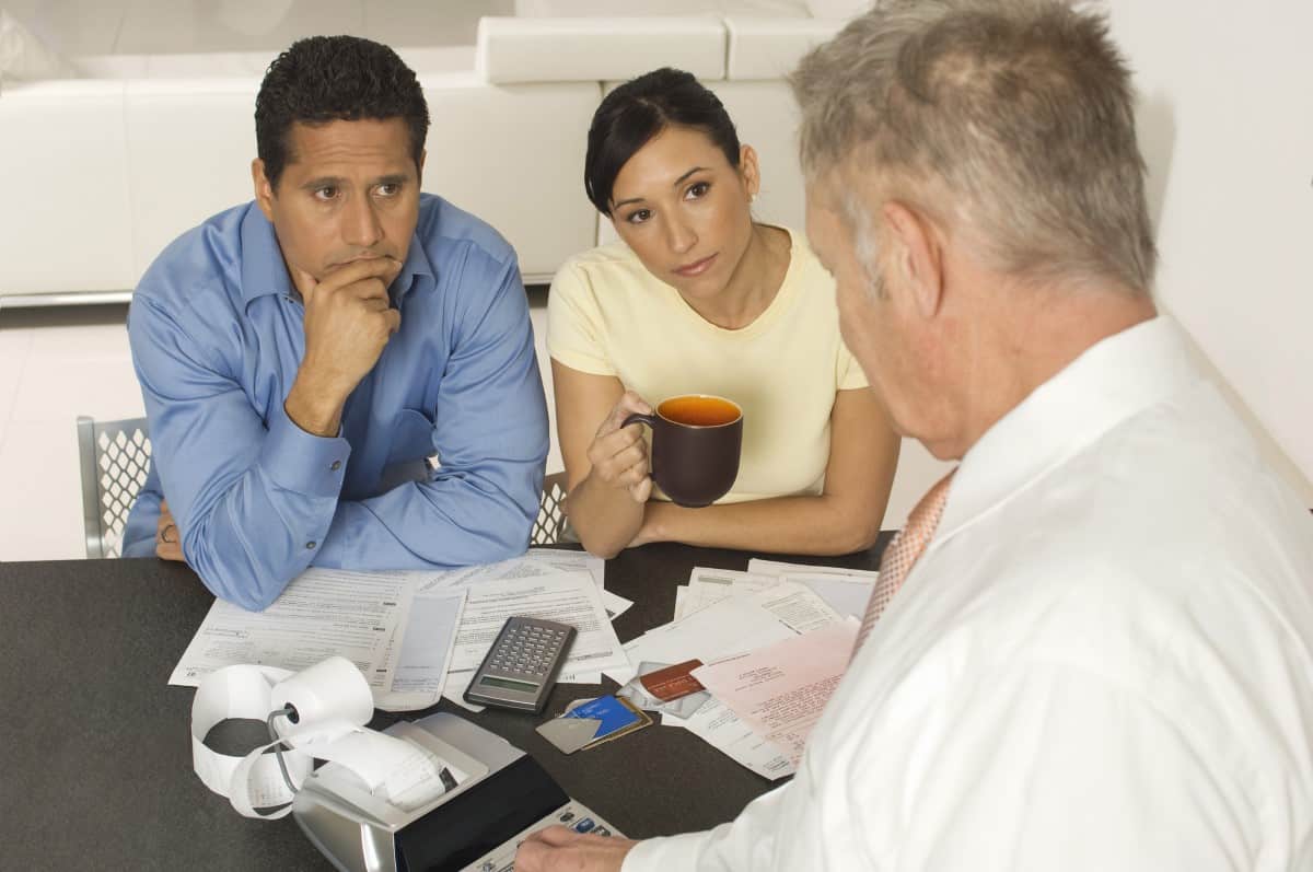 Senior financial advisor in discussion with clients at home