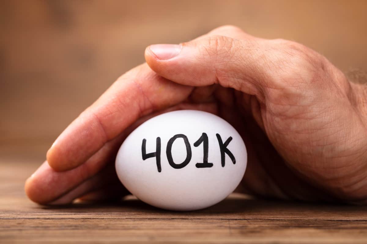 Close-up Of A Man's Hand Protecting 401k White Egg