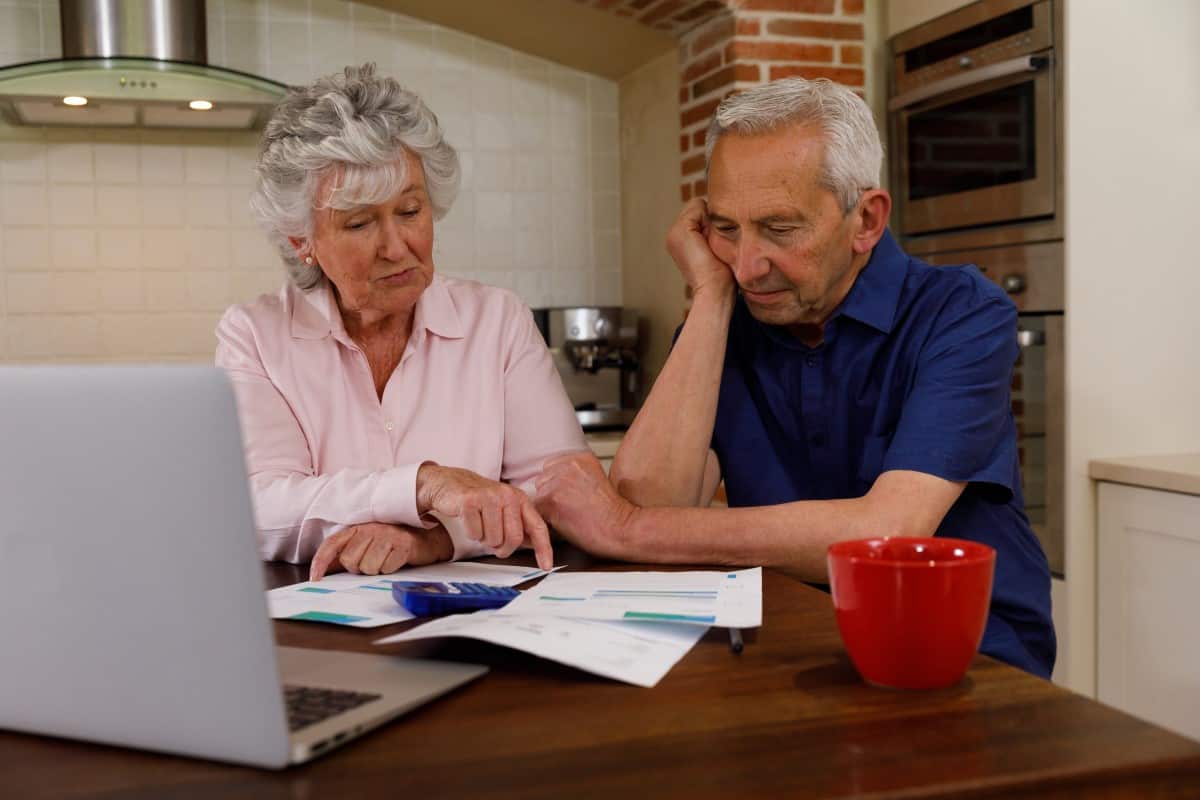 Worried senior couple looking at expenses