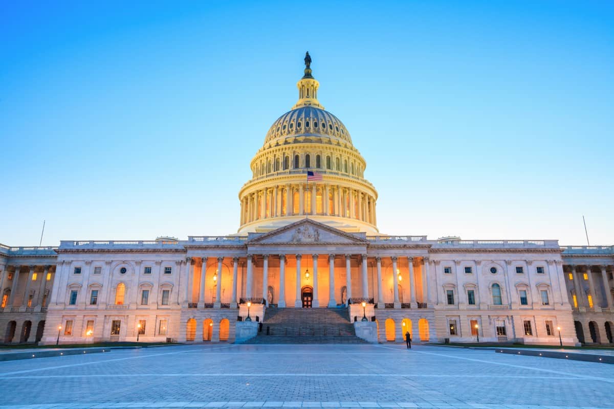 The United States Capitol building with the dome lit up at night.