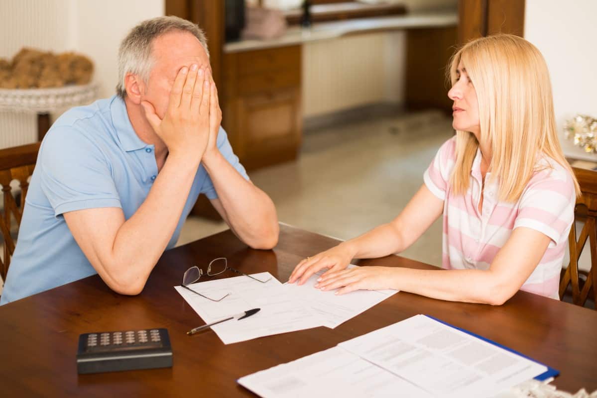 Worried couple calculating their expenses together