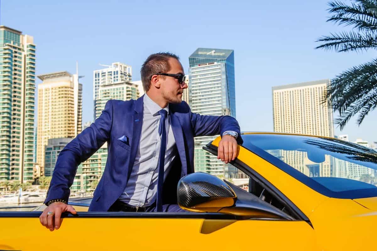 Successful businessman in yellow cabrio car. Billionaire 