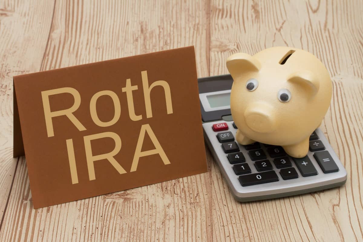 Having a Roth IRA plan, A golden piggy bank, card and calculator on wood background with text  Roth IRA