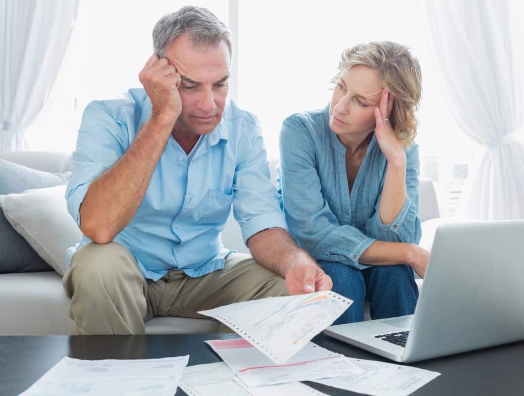 Worried Couple using laptop to pay bills 