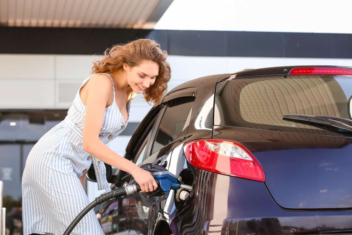 Woman refueling car at gas station 