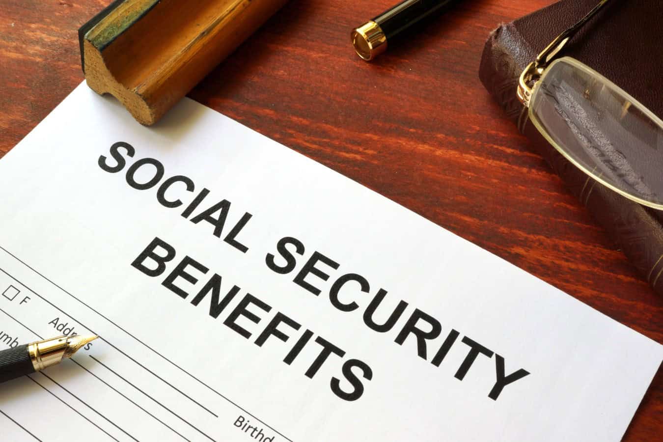 Social security benefits form, book and glasses