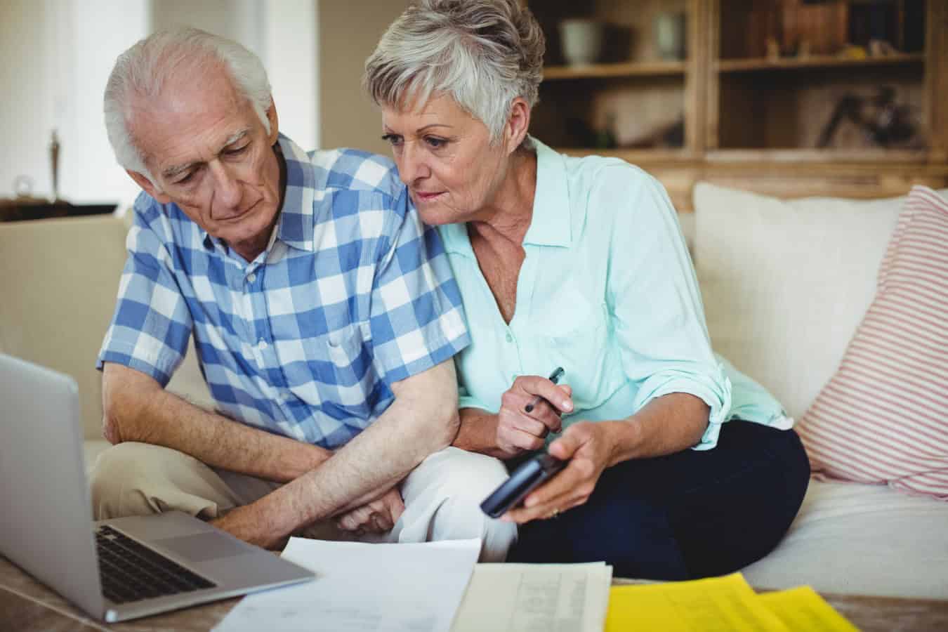 Worried senior couple checking bills