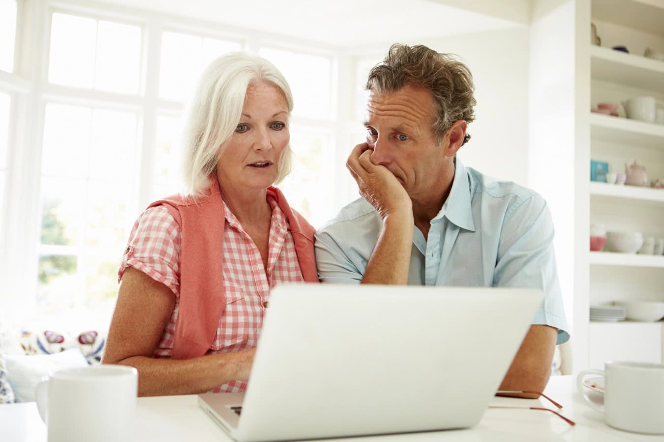 Middle Aged Worried Couple Looking At Laptop