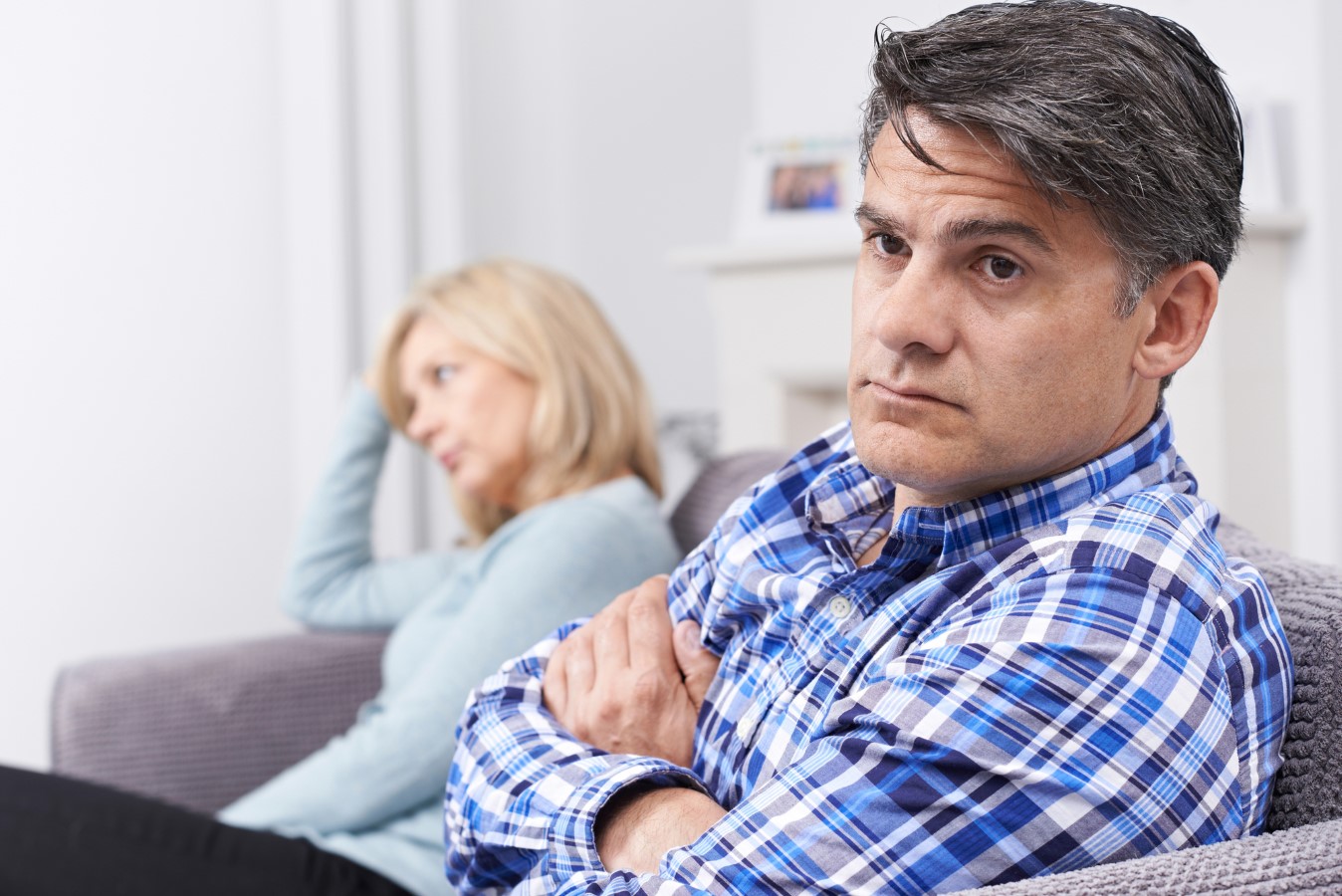 Sad Couple Sitting On Sofa