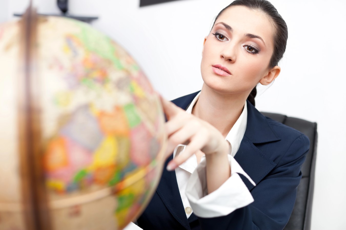 Businesswoman in office looking at globe