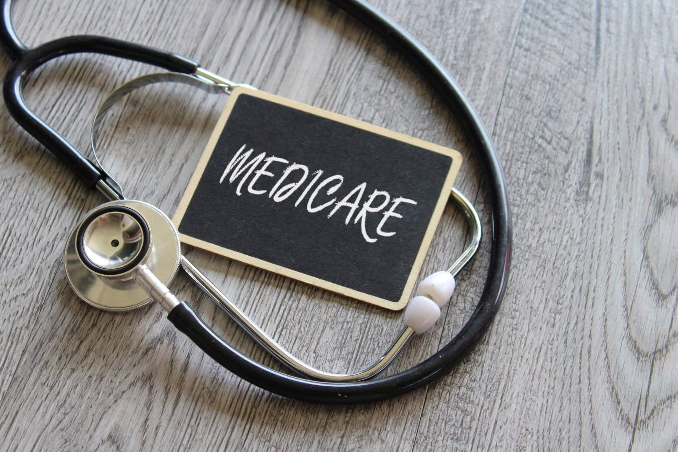 Close up image of stethoscope and chalkboard with text MEDICARE. Medical and healthcare concept