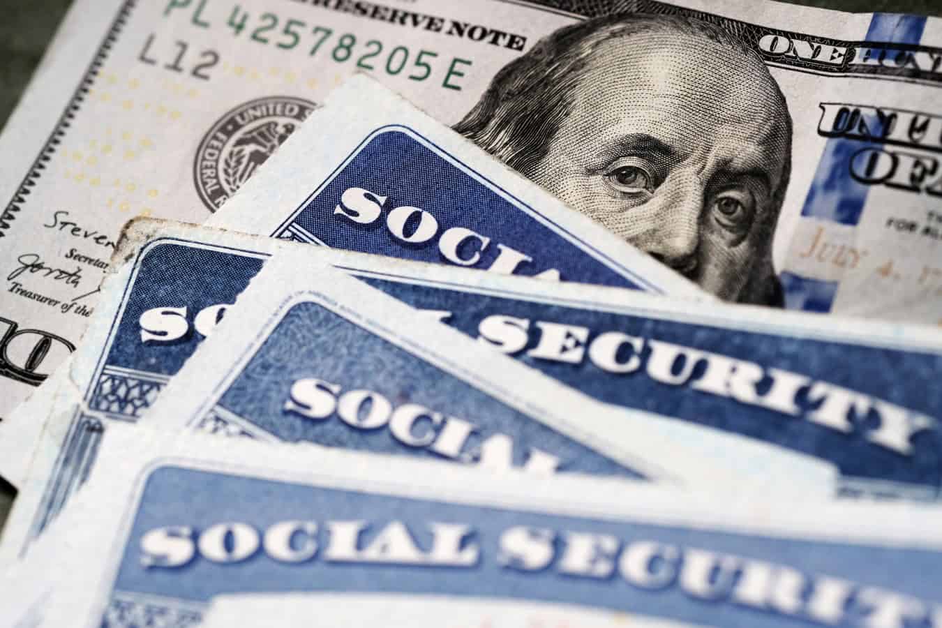 Several Social Security Cards on a US 100 dollar bill