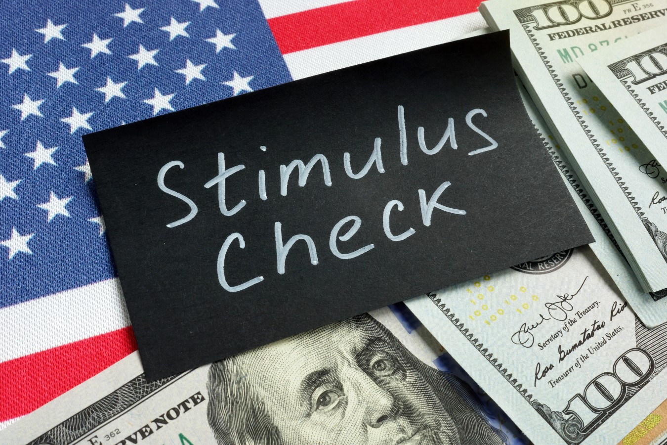 Stimulus check words, money and USA flag