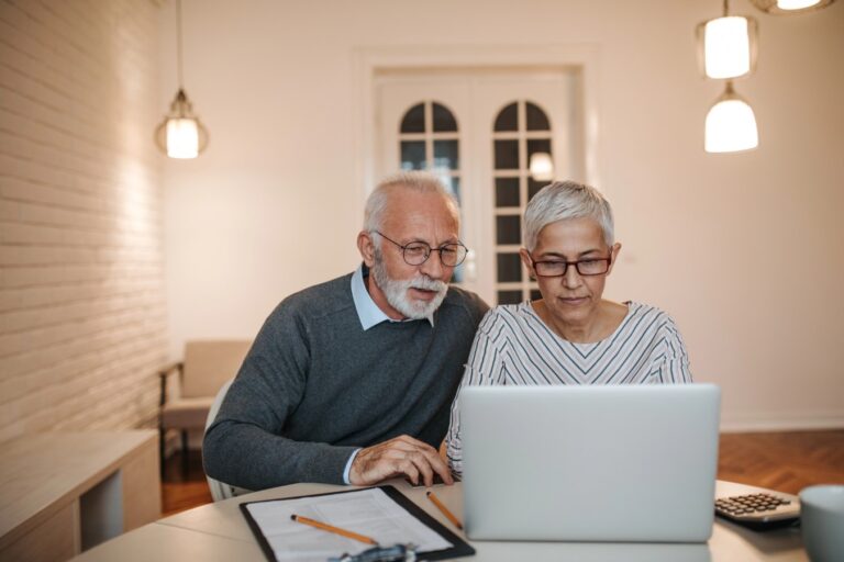A senior couple using their laptop to keep track of their budget and retirement finances