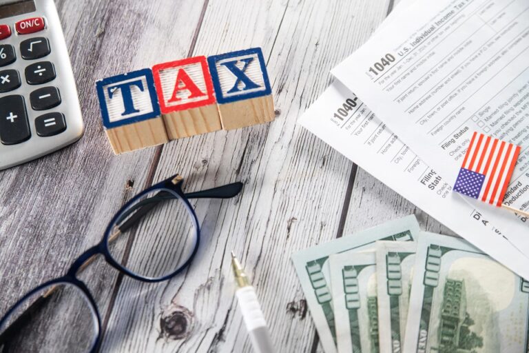 US tax form 1040, calculator and pen on wooden table