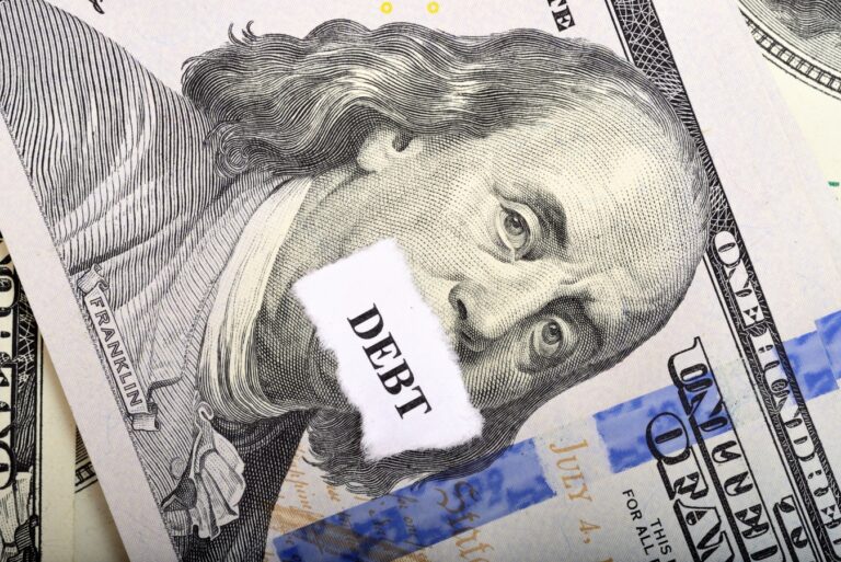 Debt concept with dollar note and paper on foreground