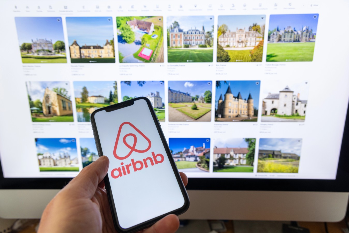 Hand holding smartphone with Airbnb application 